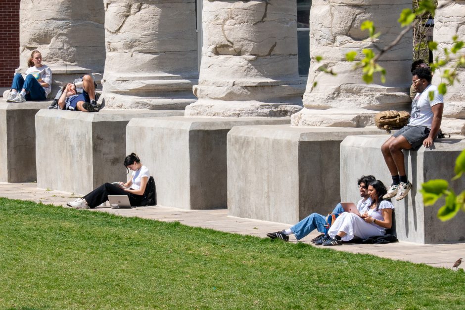 Students sit at base of the Columns