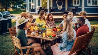 Family and friends at picnic table with fresh foods