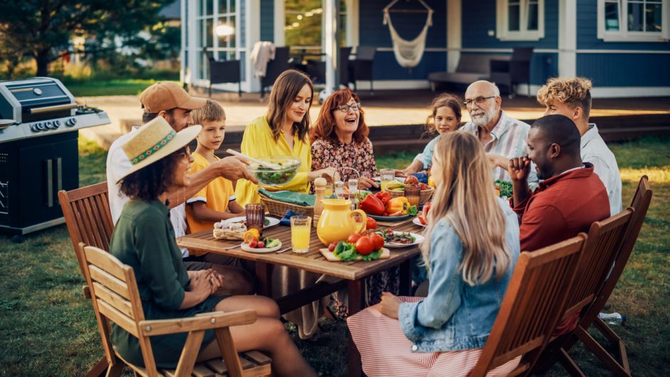 Family and friends at picnic table with fresh foods