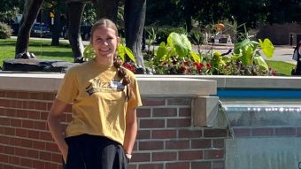 Student standing next to fountain