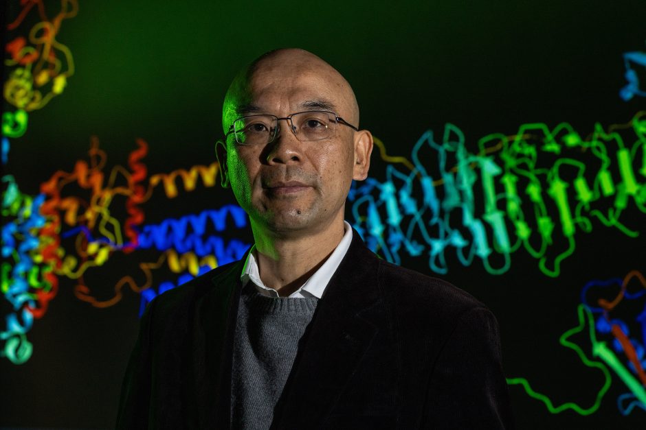 Professor with brightly colored designs in the background