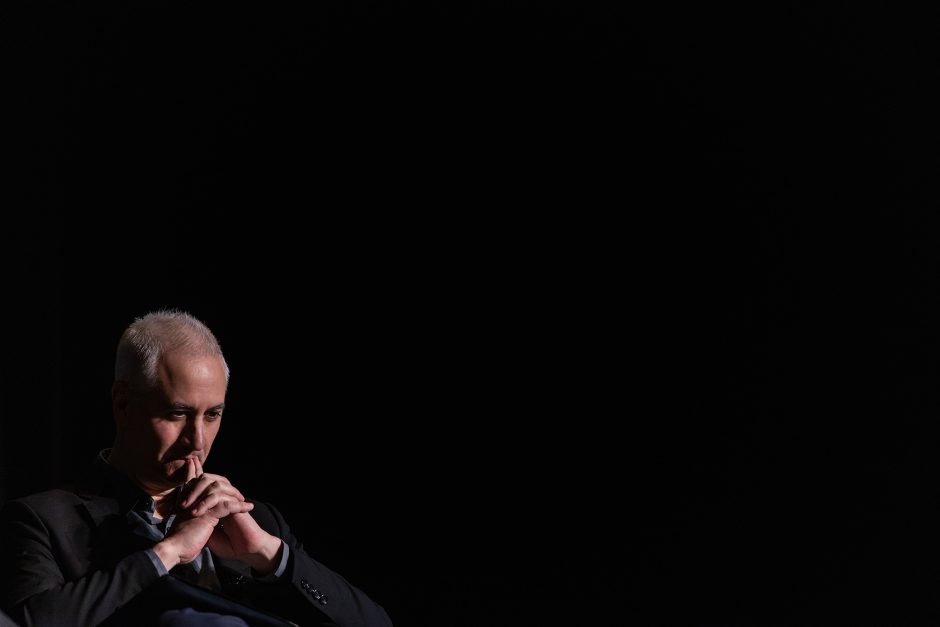 Person sitting with hands steepled in front of face