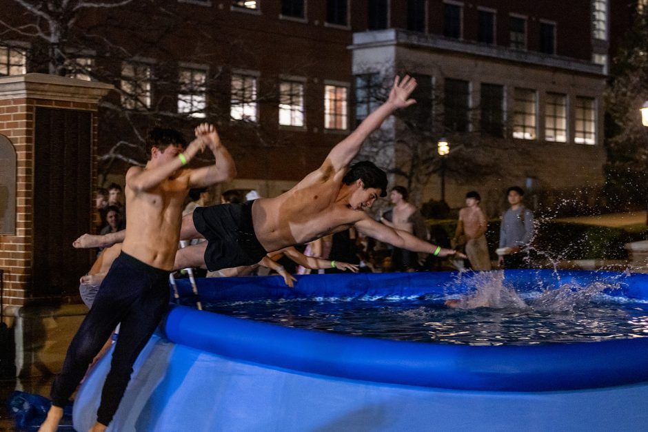 Students leaping into an inflatable pool