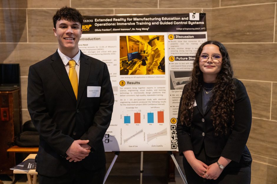 Two students standing next to research poster