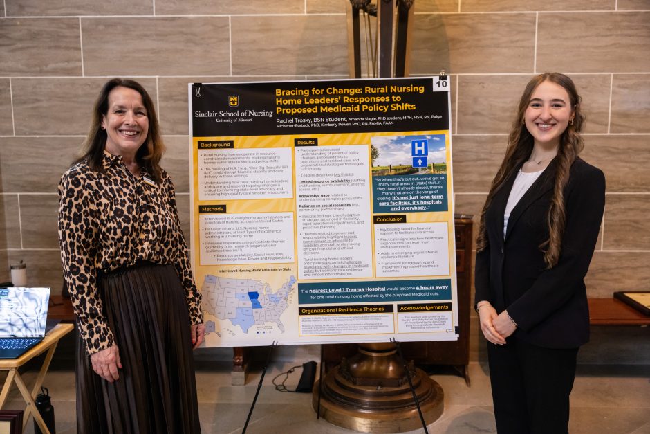 Two people standing next to a research poster
