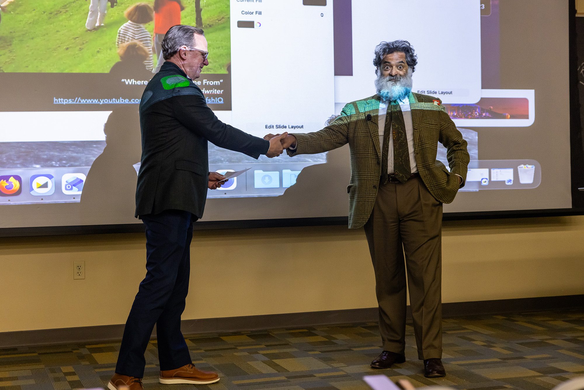 Two people shaking hands in a classroom