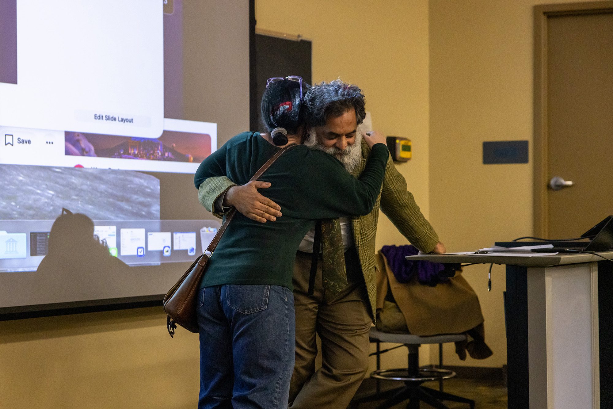 Two people hugging in a classroom