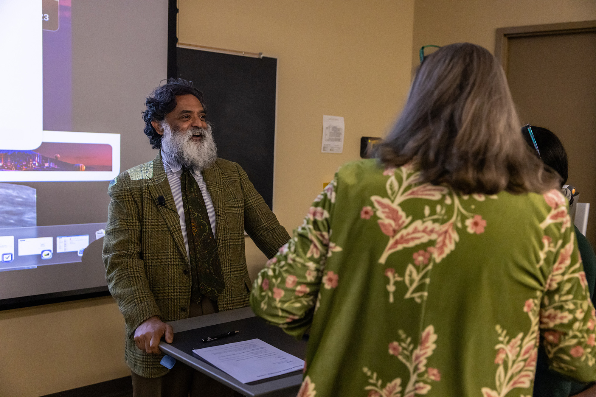 Professor speaking with people at front of classroom