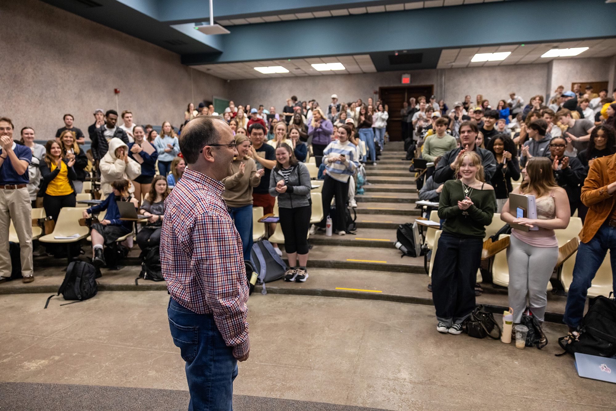 Professor in classroom where students are giving a standing ovation