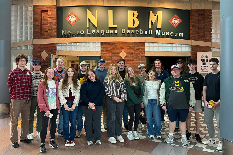 Group of students stand in front of museum