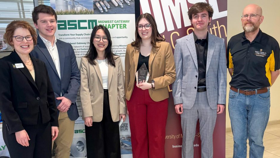 Group of people in suits with award