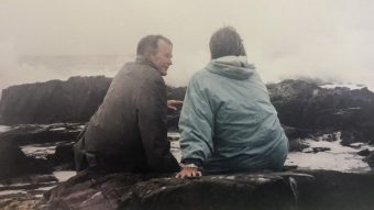 Jean Becker and George H.W. Bush sitting on rocks at the beach
