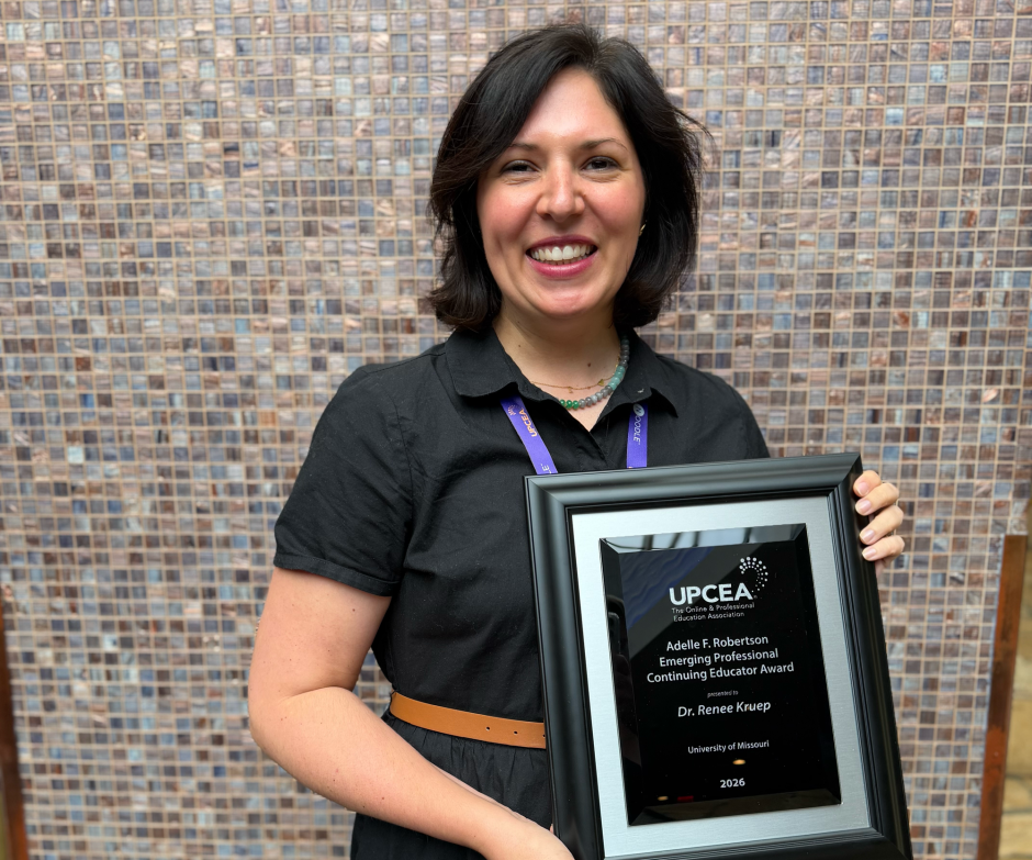 Renee Kruep holds an award from UPCEA