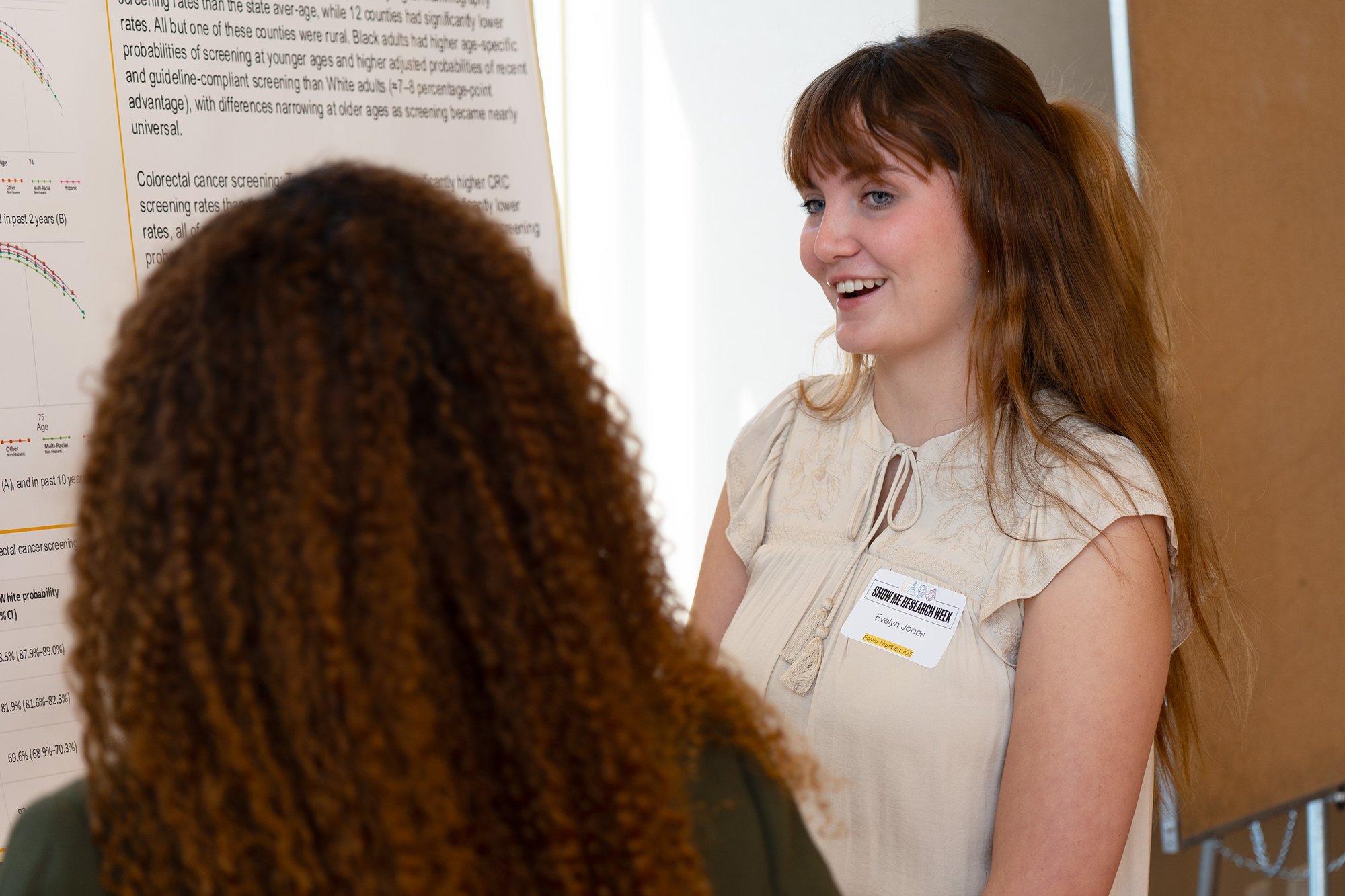 Student stands by poster