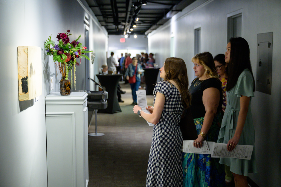 Attendees look at artwork