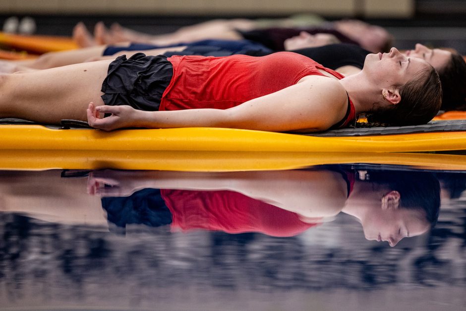 Student lying on a paddle board in a pool