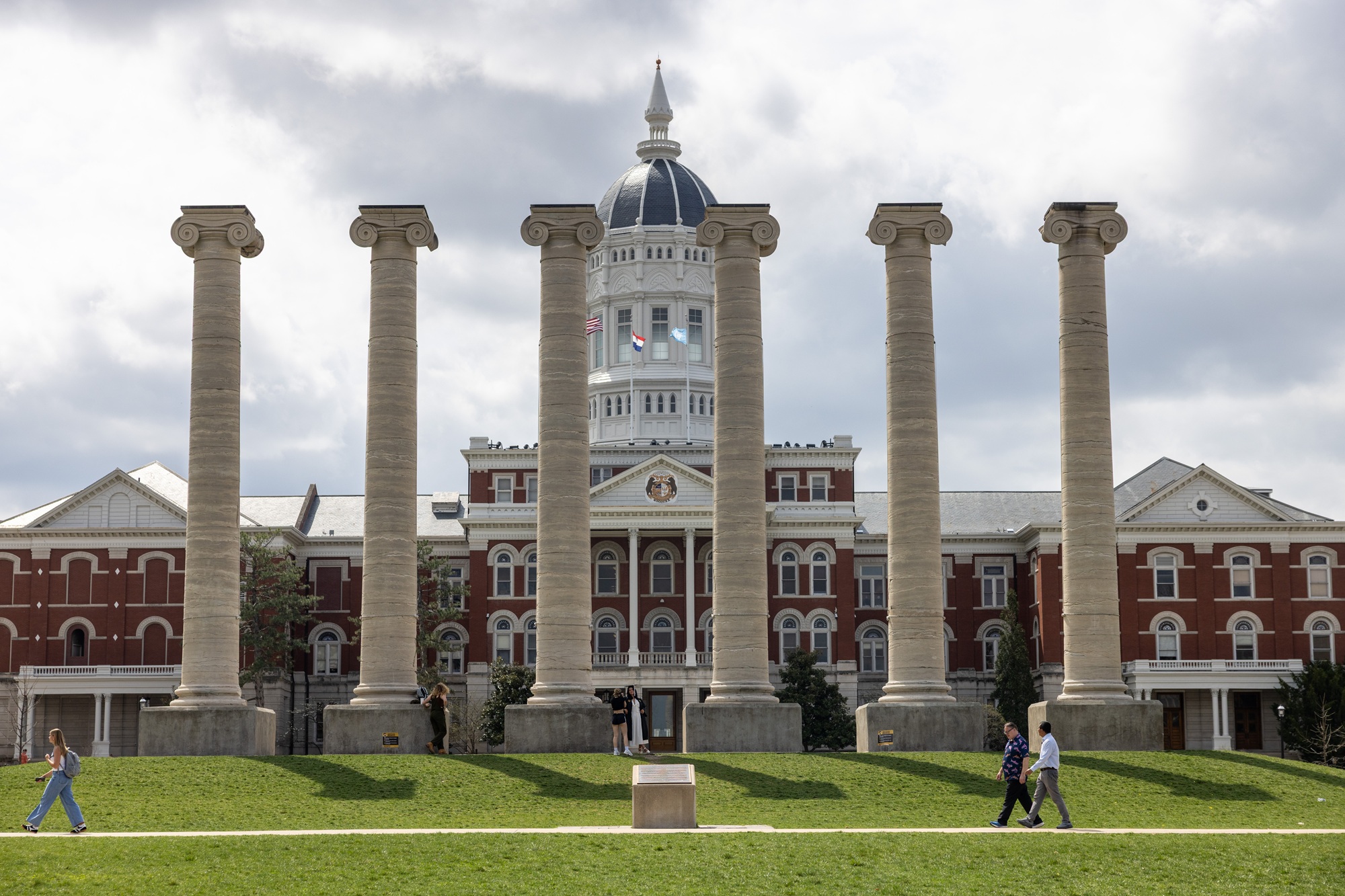 two researchers walking in front of the columns at the university of missouri