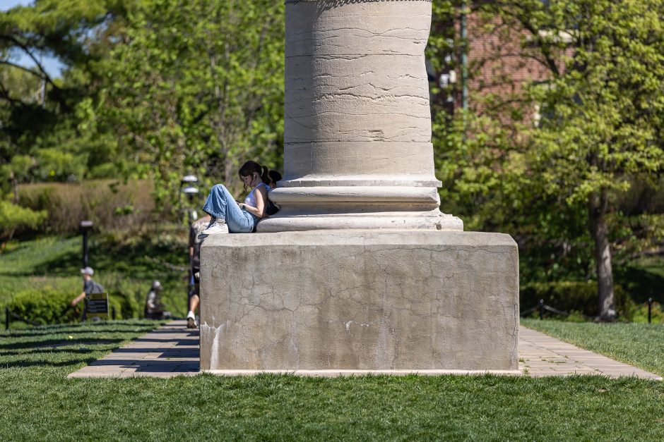 Student sitting on the base of the Columns