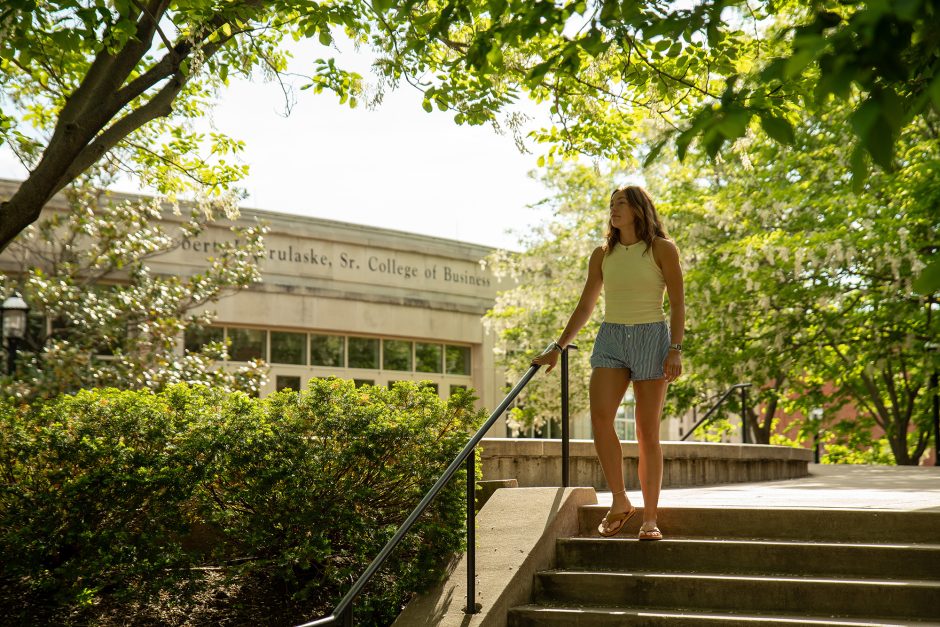 Student walking down a outdoor staircase on campus
