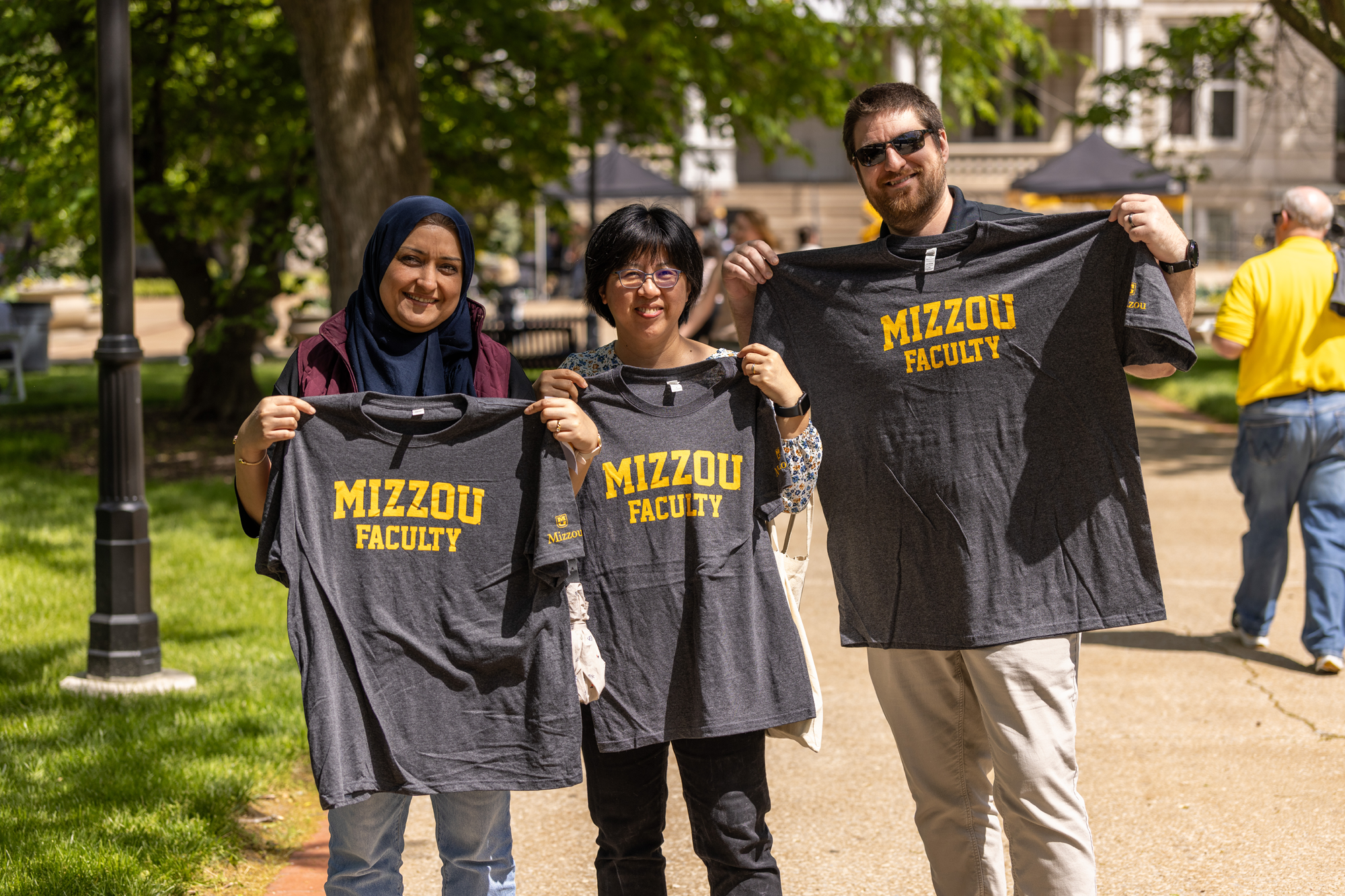 Faculty hold up t-shirts