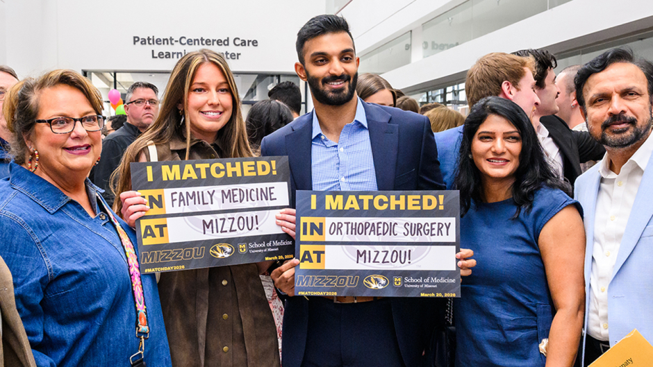 Two people hold signs on Match Day