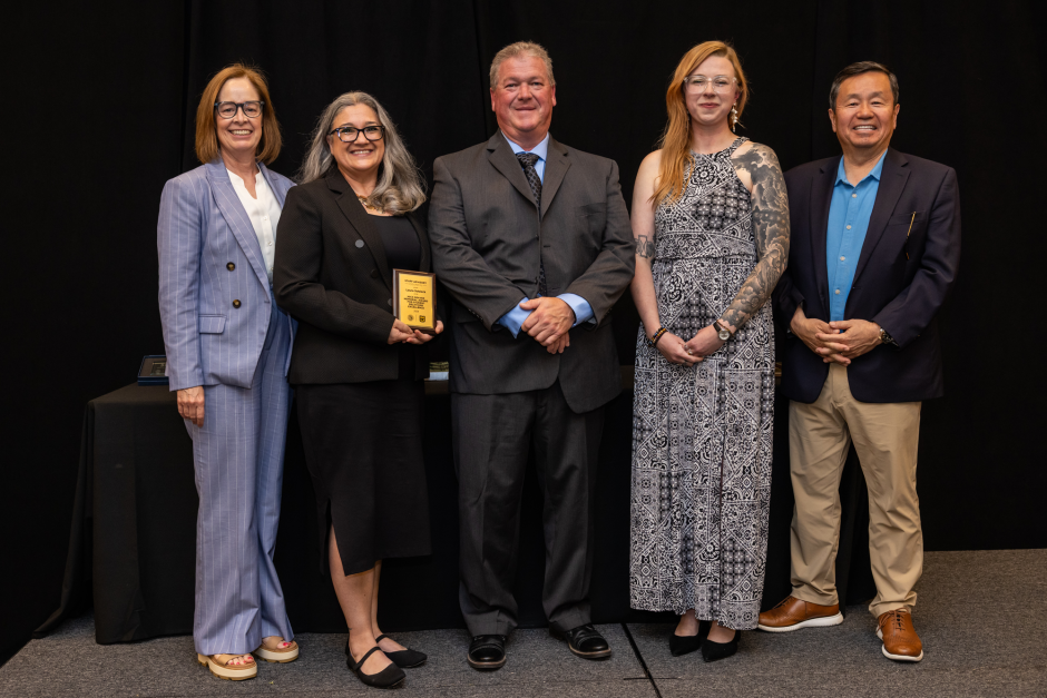 Laura Sobieck holds award with university leaders