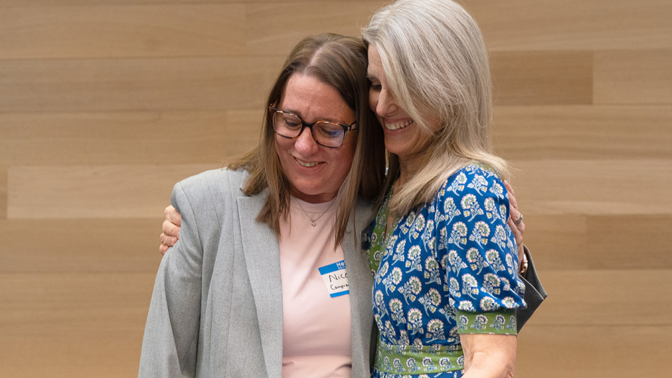Two people hug at awards ceremony