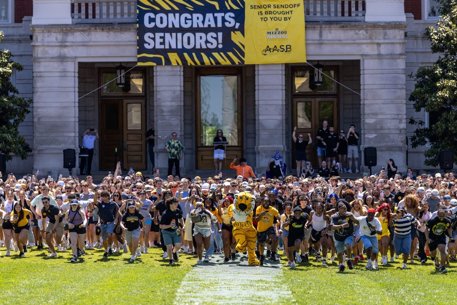 Truman the Tiger and many students beginning to run toward the Columns