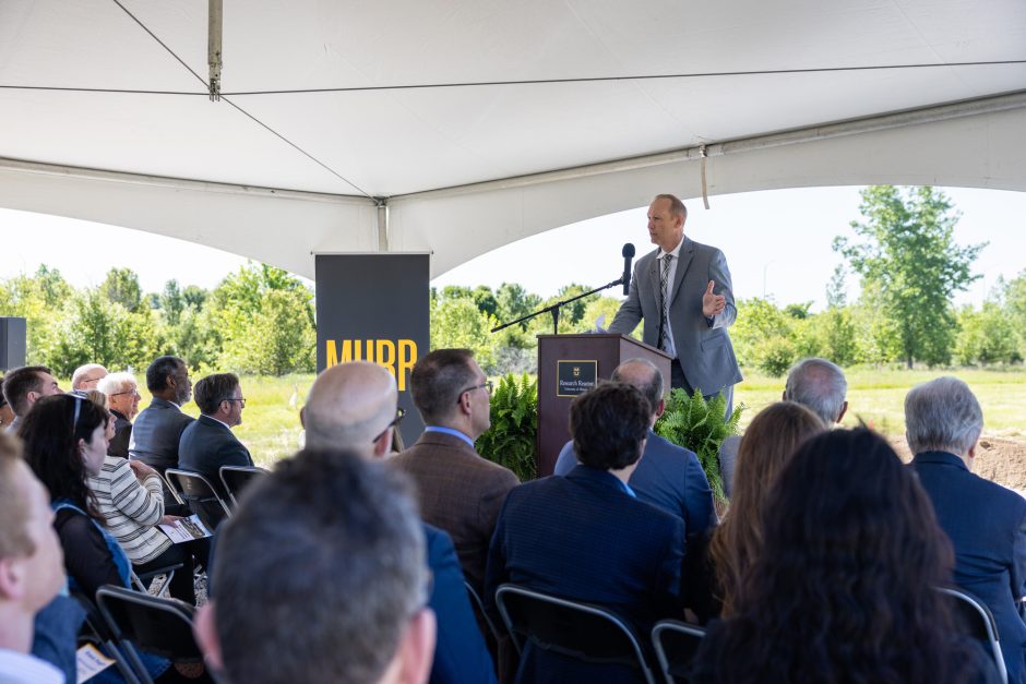 Person speaking at a podium at an outdoor event