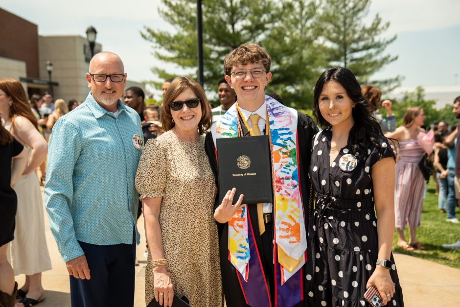 Graduate and family posed outside