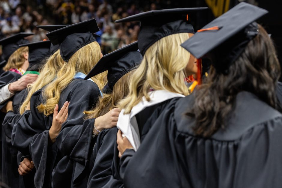 Graduates standing with arms around each others' backs