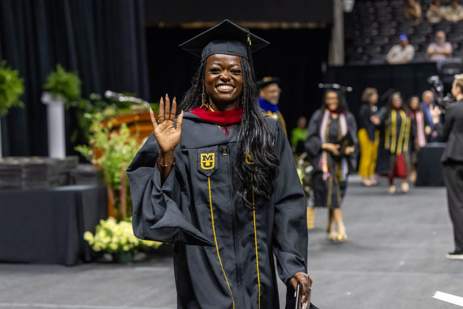 Graduate waving and smiling