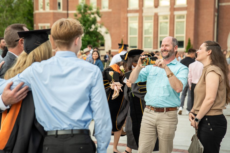 Family member taking photos of graduate