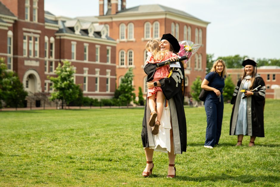 Small child hugging a graduate