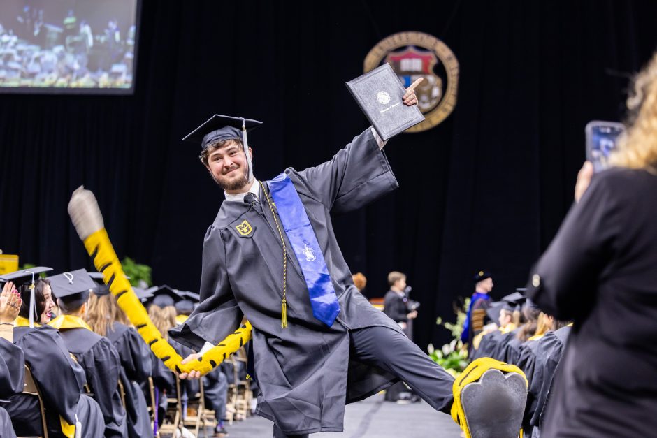 Graduate swinging the Truman the Tiger tail