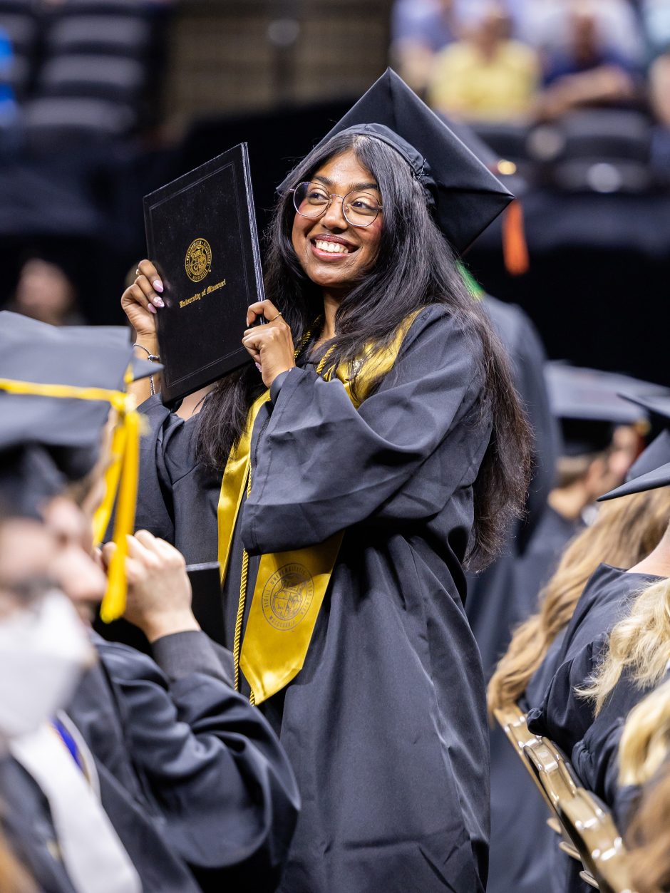 Graduate holds up diploma