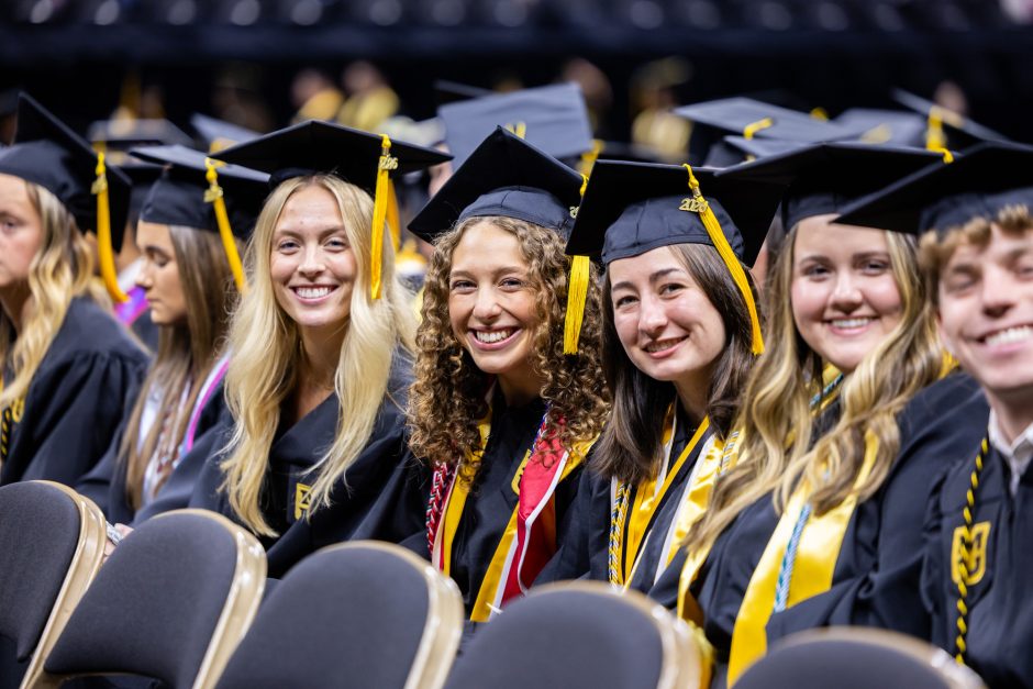 Group of graduates seated in their row and smiling