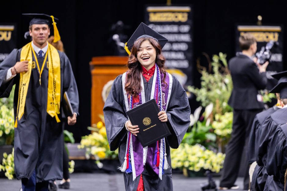 Graduate walking with diploma