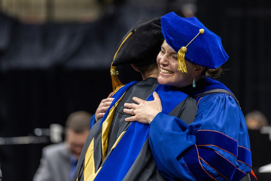 Graduate and faculty member hugging