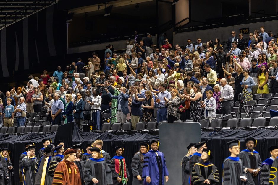 Audience cheering as graduates walk in