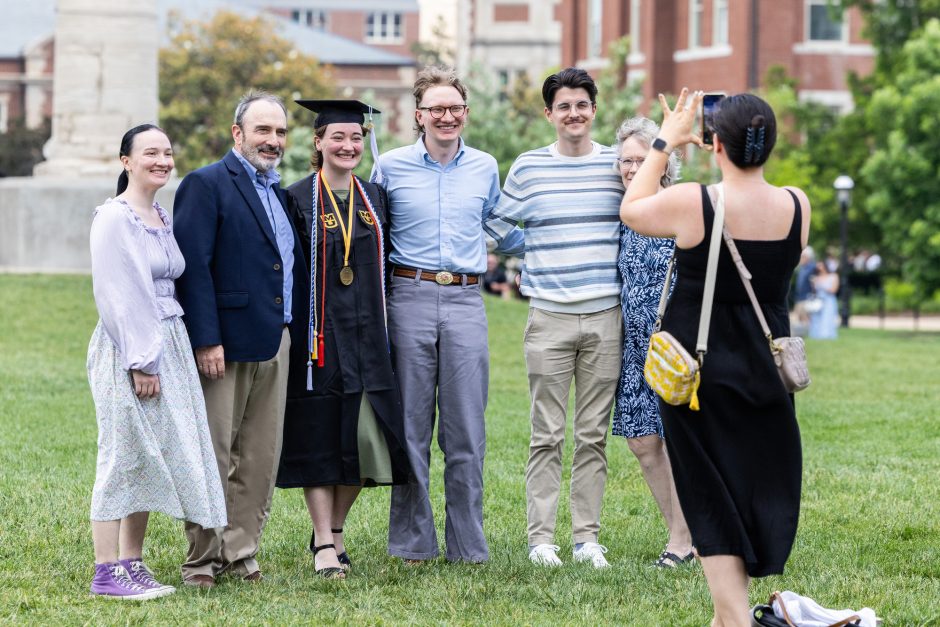 Graduate and family posing for photos outside