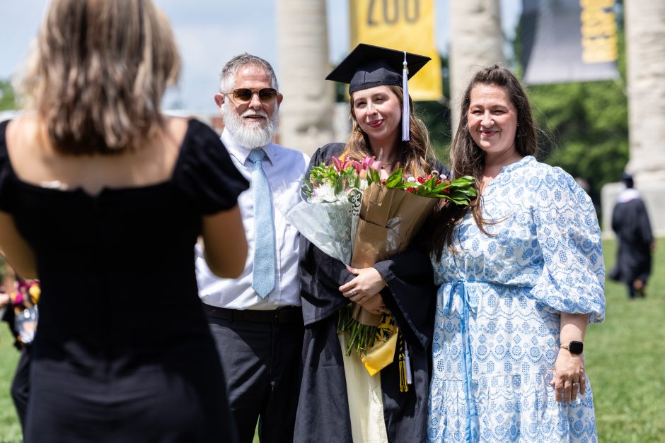 Graduate posing with family outside