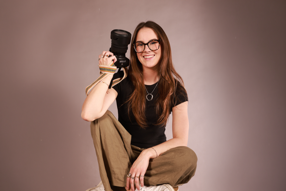 Portrait of Annie George holding a camera