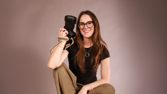 Portrait of Annie George holding a camera