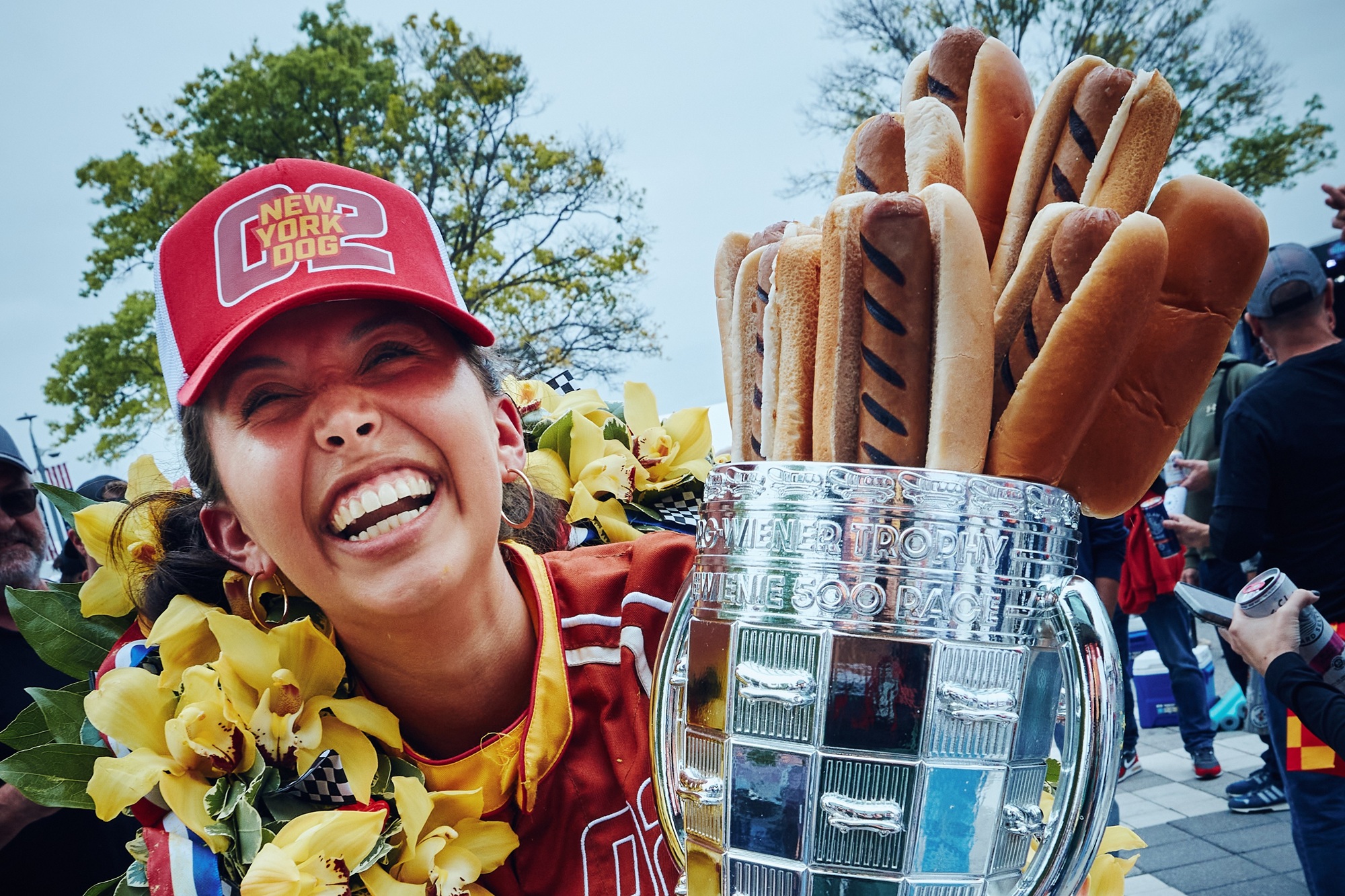 063026_Camila Camila Fowler celebrates in victory lane after the Wienie 500 with a wreath and a trophy with hot dogs sticking out of it