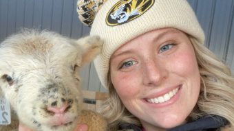 Close up of Addie Kemper holding a lamb.