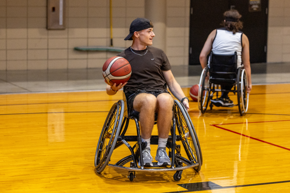 A person in a wheelcchair plays basketball