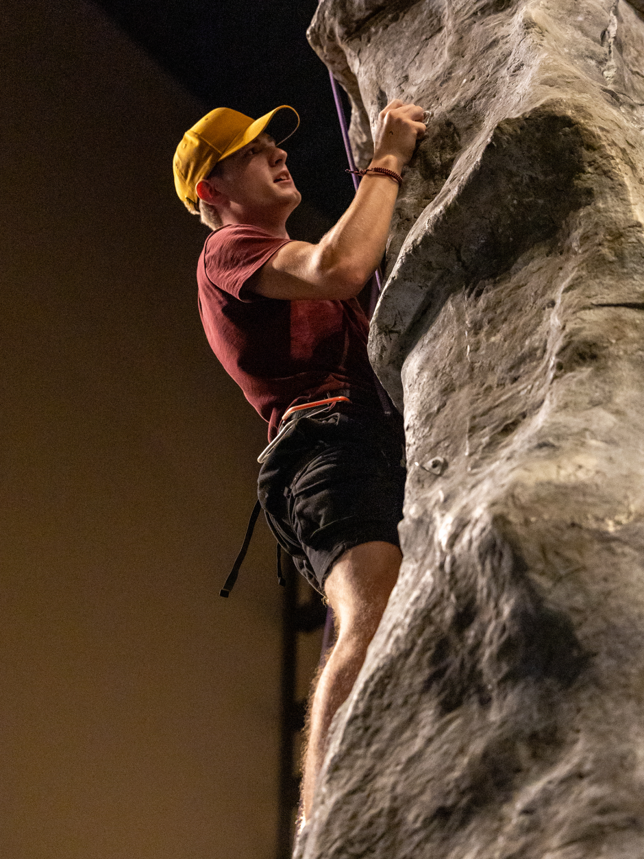 A student rock climbs