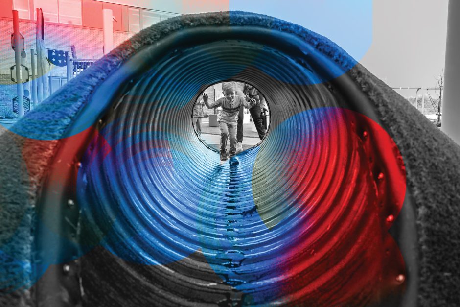 a boy walks through a playground tunnel