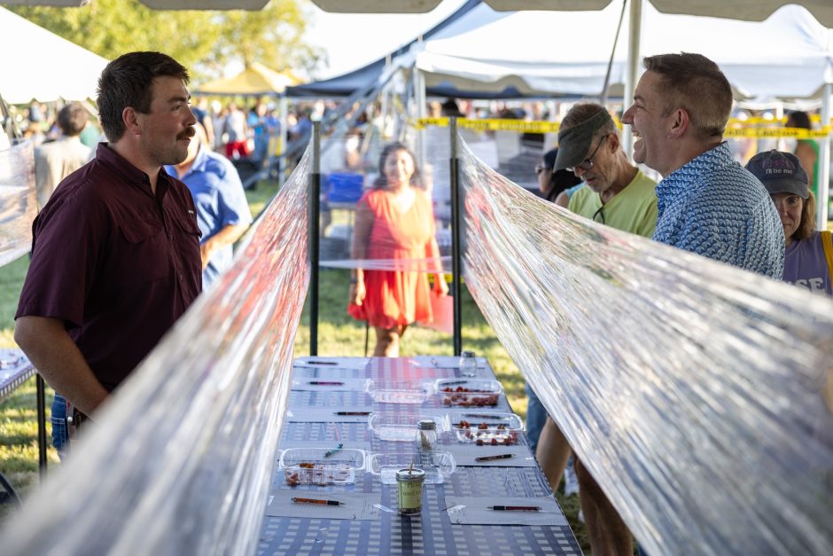 William Lee talks with a visitor at the annual Tomato Festival